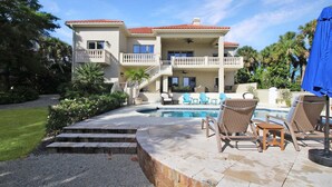 A two-story house with a swimming pool, outdoor furniture, and a covered patio area. - Waterfront Neo Mediterranean Home On Casey Key - Tidewater Manor (Nokomis)