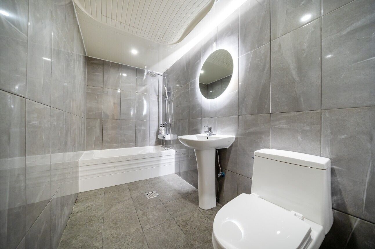 A modern bathroom with a bathtub, sink, and toilet.