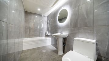 A modern bathroom with a bathtub, sink, and toilet.