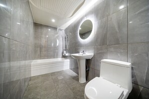 A modern bathroom with a bathtub, sink, and toilet. - SOO HOTEL (Seoul)