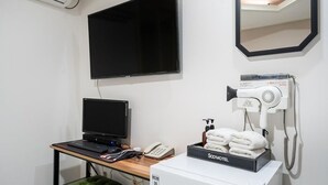 A room with a desk, a computer, a hairdryer, and a box labeled 'SooMotel'. - SOO HOTEL (Seoul)