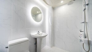 A modern bathroom with a toilet, pedestal sink, and shower. - SOO HOTEL (Seoul)