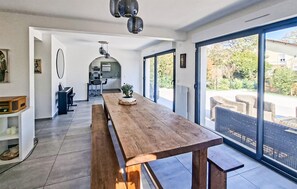 Een moderne keuken met een eethoek, een grote houten tafel en uitzicht op de omgeving.