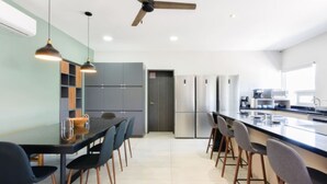 Eine moderne Küche mit Kochinsel, Pendelleuchten und Deckenventilator.