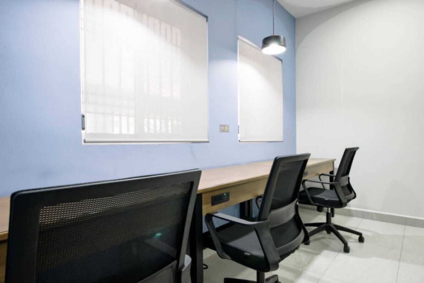 A conference room with a long table, two chairs, and a whiteboard.