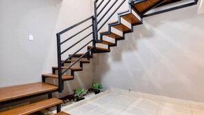A staircase with wooden steps and black railings, a bench, and a small plant arrangement on the floor. - 1 King, 4 Double bed, 2 Sofa bed, 2 Parking, 12ppl (Monterrey)