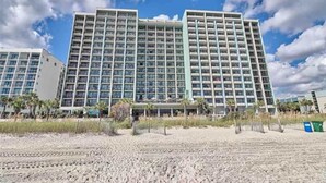 A multi-story hotel with a modern design, featuring a large number of balconies and a central courtyard. - Decorated Oceanfront  Condo with Amazing Heated Pool (Myrtle Beach)