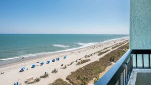 A beach with umbrellas and a view of the ocean. - Decorated Oceanfront  Condo with Amazing Heated Pool (Myrtle Beach)