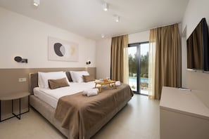 A modern hotel room with a large bed, a small table, a TV, and a balcony with curtains. - Villa La Mari (Istria - Poreč) (Poreč)