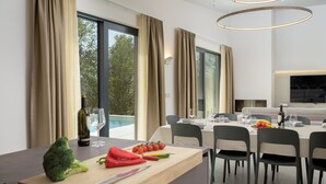 Un comedor moderno con una mesa de madera, sillas y vistas al exterior.