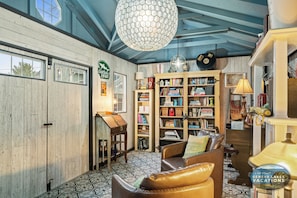Una habitación acogedora con una estantería de madera, un sofá de cuero y un suelo con diseño.