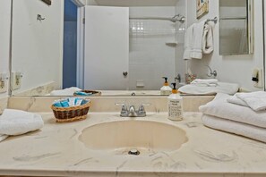 A bathroom with a large mirror, a sink, a shower, and towels. - Panoramic Ocean View Retreat - Family Friendly (La Mesa)