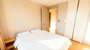 Une chambre à coucher avec un lit, un plancher en bois et une armoire.