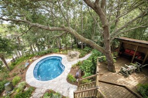 A backyard with a swimming pool, wooden deck, and outdoor furniture. - Sea Haven | Private Heated Pool, Garden Oasis, Screened Porch & 2 Blocks to Folly Beach (Folly Beach)