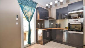 A modern kitchen with stainless steel appliances, a built-in oven, and a coffee maker. - Stunning home in Arles (Arles)