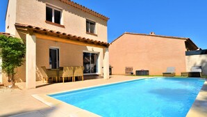 A two-story building with a swimming pool, outdoor furniture, and a patio area. - Stunning home in Arles (Arles)