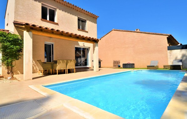 A two-story building with a swimming pool, outdoor furniture, and a patio area. - Stunning home in Arles (Arles)