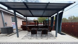 An outdoor patio with a covered dining area, a pool, and a wooden deck. - Comfortable 3BR Home w/ POOL! Near Lackland AFB & Seaworld for BMT Families (San Antonio)