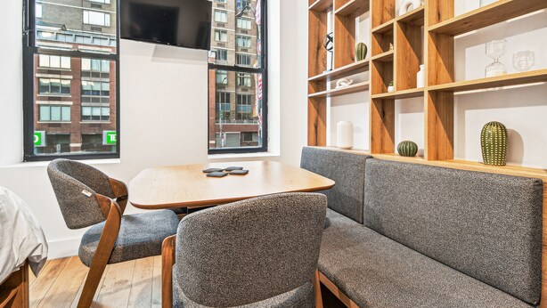 Um interior moderno com um sofá, cadeiras, uma mesa, uma TV e uma estante.