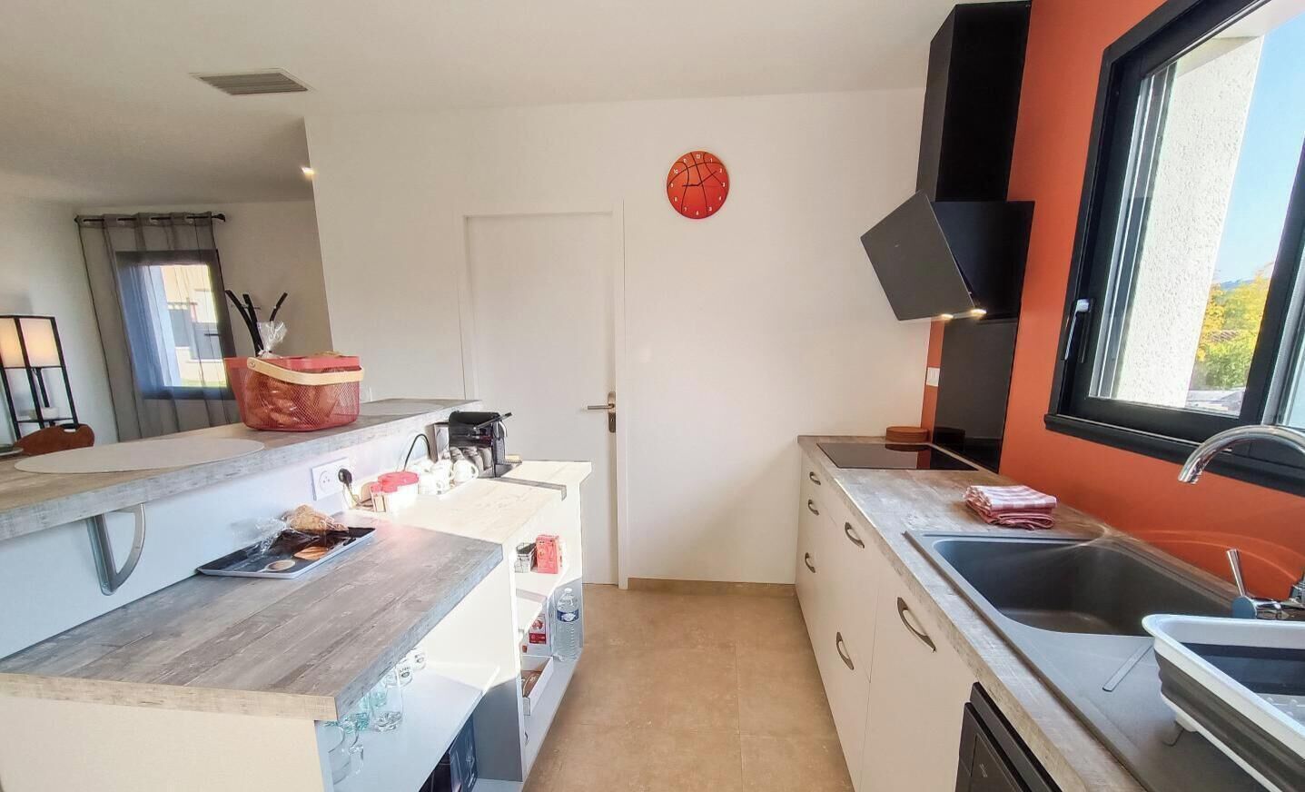 Une cuisine de taille réduite, dotée d’un plan de travail en bois, d’un évier et d’une fenêtre offrant une belle vue.