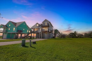 A modern two-story house with a large front lawn and a garage. - NEW! Serene Coastal Escape with Gulf Views (Galveston)