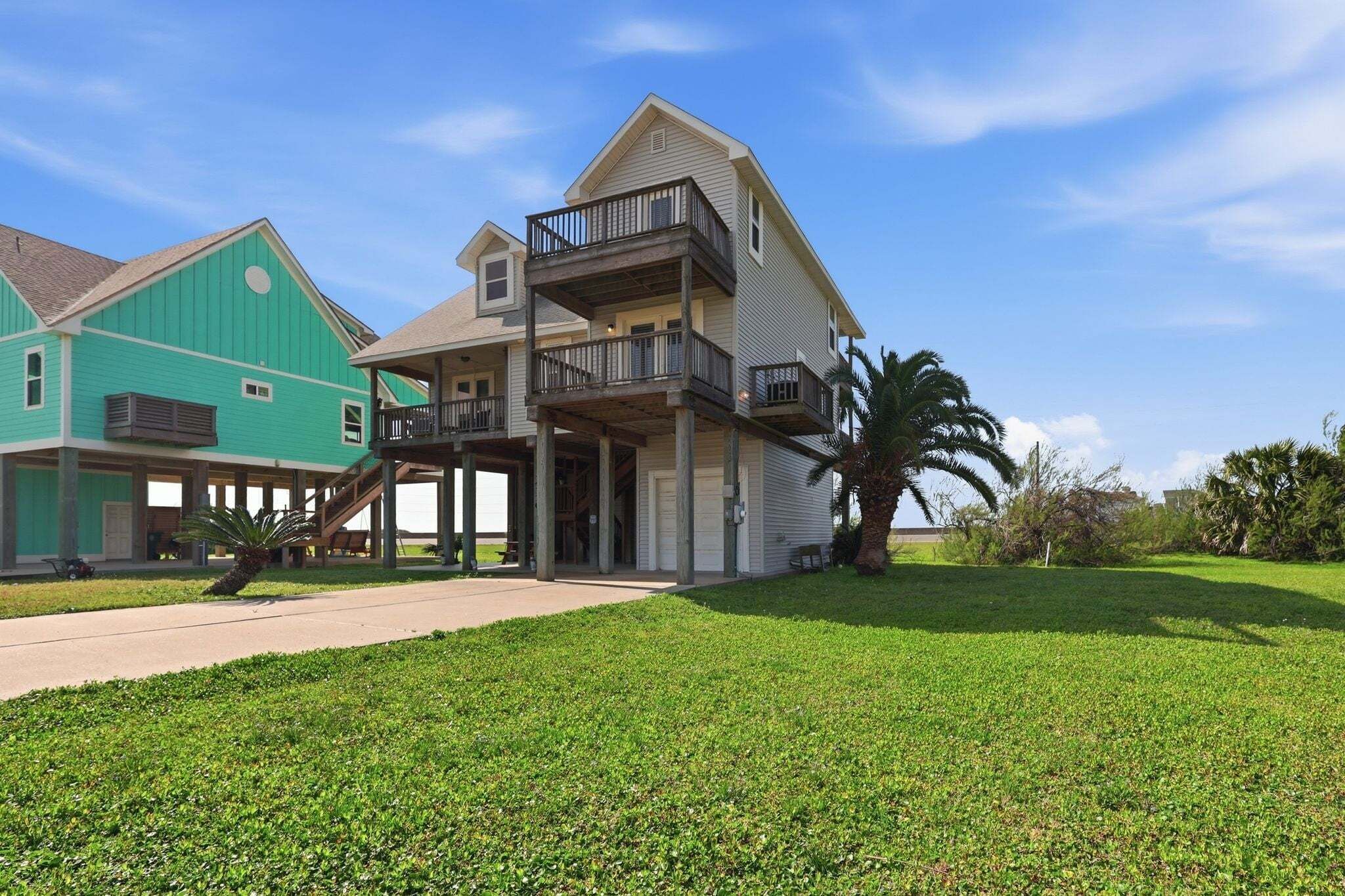 A two-story house with a balcony, a covered porch, and a well-maintained lawn.