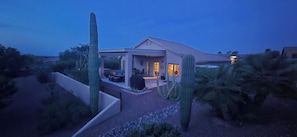 Una casa con patio, cactus y piscina.
