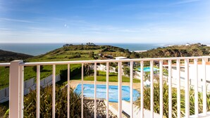 A balcony with a view of a pool and a distant landscape. - Villa Serra e Mar - Holiday home (Serra da Pescaria)