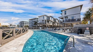 A swimming pool with lounge chairs and a wooden deck. - Pelican Haven • Beach Access • Community Pool • Fishing Pier (Gulf Shores)