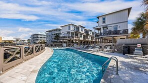 Ein Schwimmbecken mit Liegestühlen und einer Holzterrasse.