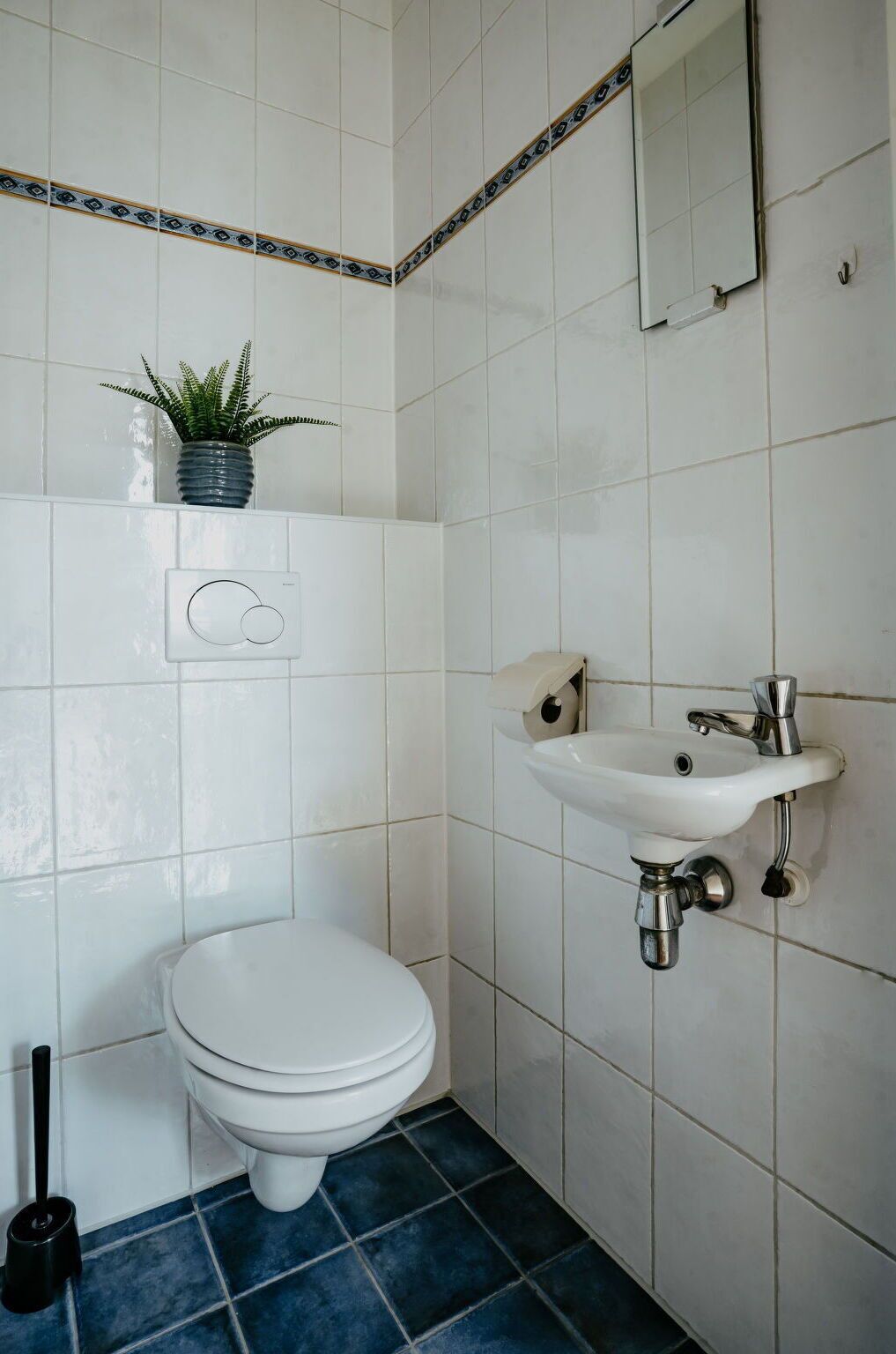 Ein Badezimmer mit Toilette, Waschbecken und Spiegel.