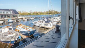 A view of a marina with several boats docked, a building with large windows, and a clear sky. - Stunning private villa for 6 people with WIFI, TV, terrace and pets allowed (Uitgeest)