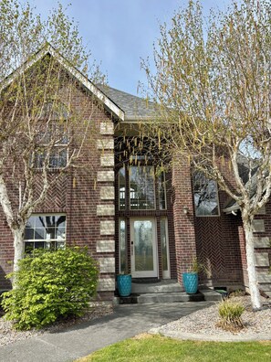 A brick building with a herringbone pattern, large windows, and a central entrance.