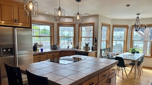 A modern kitchen with a central island, wooden cabinets, and pendant lighting. - Lakefront Escape Near Gorge Amphitheater (Moses Lake)