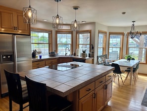 A modern kitchen with a central island, wooden cabinets, and pendant lighting. - Lakefront Escape Near Gorge Amphitheater (Moses Lake)