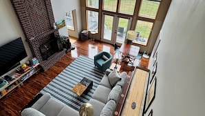 A spacious living room with a fireplace, a large window, a ceiling fan, and a pool table. - Lakefront Escape Near Gorge Amphitheater (Moses Lake)