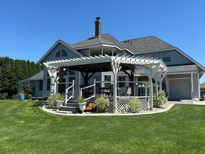 A two-story house with a covered porch, a chimney, and a garage. - Relax on Moses Lake Waterfront (Moses Lake)