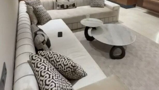 Una sala moderna con un sofá modular, una mesa de centro y una televisión.