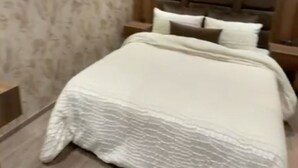 Un dormitorio con una cama grande, cabecera de madera y pared con estampado.