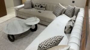 Una sala de estar moderna con un sofá modular, una mesa de centro redonda y un cojín estampado.