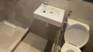 Un baño con ducha, lavamanos, inodoro y espejo con iluminación integrada.