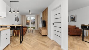 Un appartement moderne comprenant une cuisine, un coin repas, un salon et un balcon.