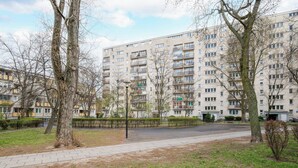 A residential building with multiple floors, balconies, and a paved walkway. - Las Bielański Homely Apartment (Warszawa)