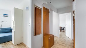 A modern interior with a sofa, wooden wardrobe, and a dining area. - Las Bielański Homely Apartment (Warszawa)