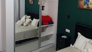 A bedroom with a bed, a wardrobe, and a painting on the wall. - Apartment Achada St Antonio Rua Principal AC, WIFI (Praia)
