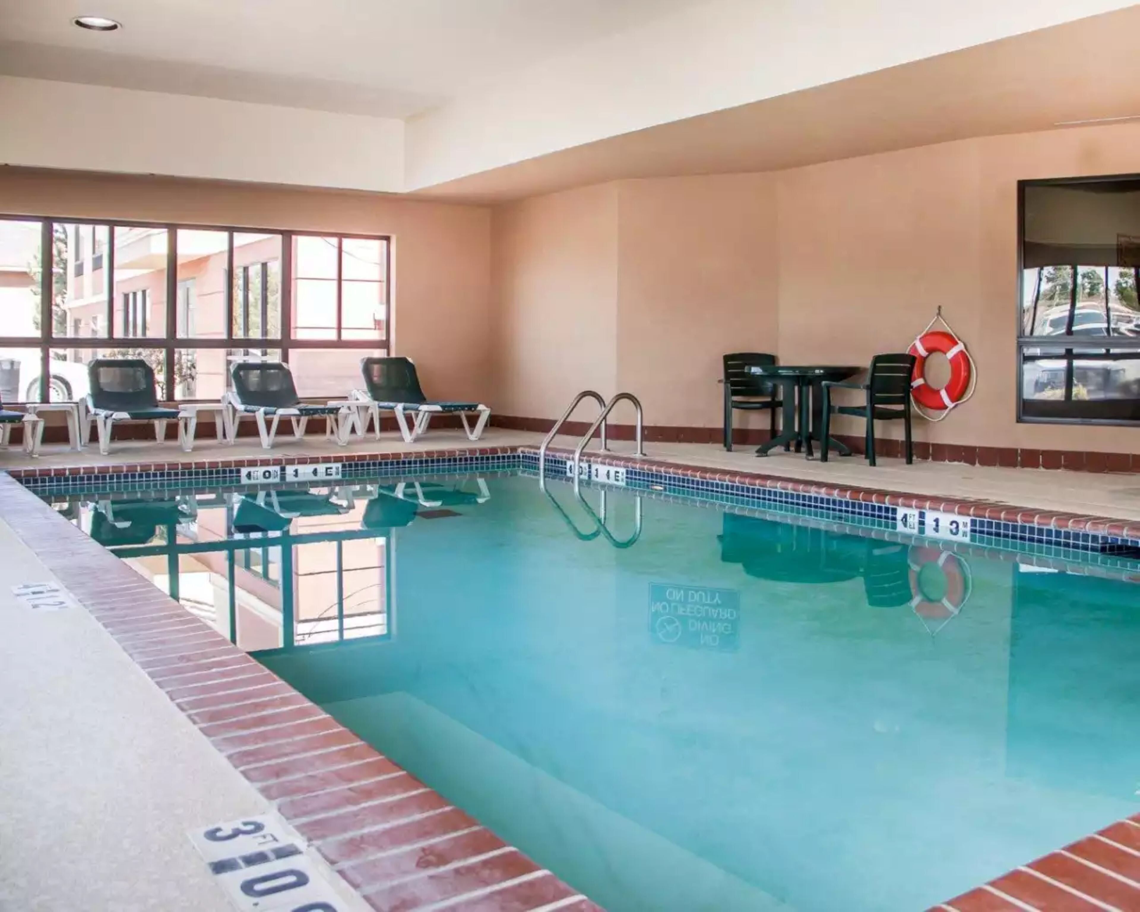 An indoor swimming pool with lounge chairs and a lifebuoy.