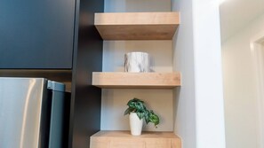 A kitchen with a built-in refrigerator, wooden shelves, and a potted plant. - Serene Dwelling Home-4 Bedroom,pool Table Near Yeg- With AC (Edmonton)