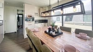 Una cucina moderna con zona pranzo, ampie finestre e vista sulla città.