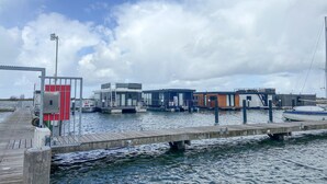Una proprietà sul lungomare con un molo, case galleggianti e una barca.