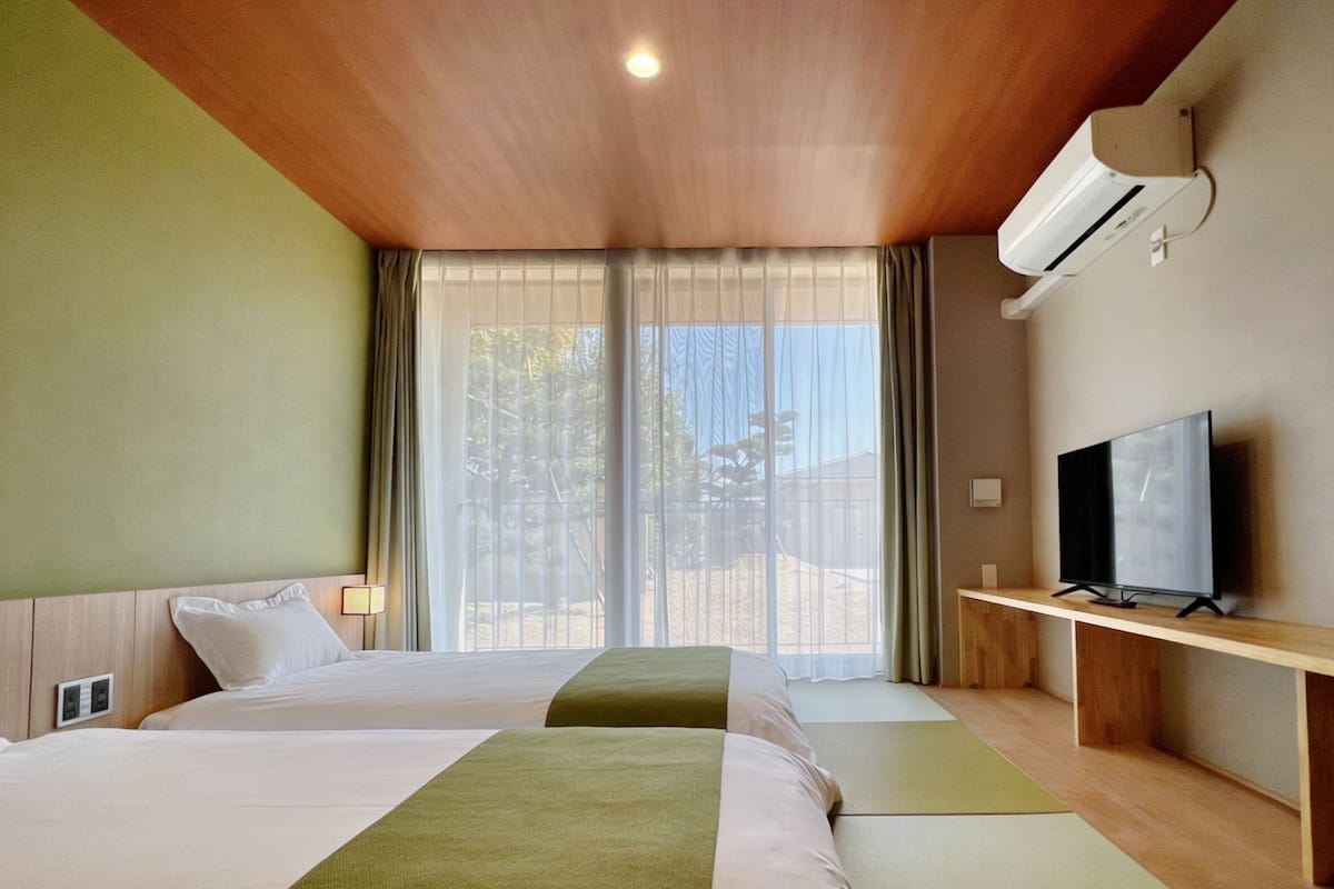 Une chambre d’hôtel avec deux lits, une télévision et un appareil de climatisation.